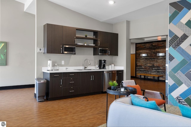 kitchen with appliances with stainless steel finishes, light hardwood / wood-style floors, sink, and dark brown cabinetry