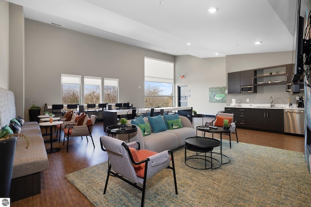 living room featuring dark hardwood / wood-style flooring, high vaulted ceiling, and sink