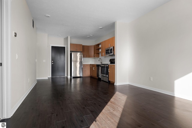 unfurnished living room with sink and dark hardwood / wood-style floors