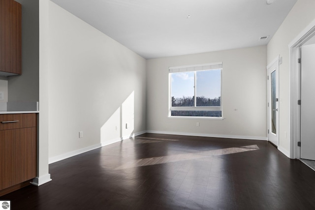 unfurnished room with dark wood-type flooring