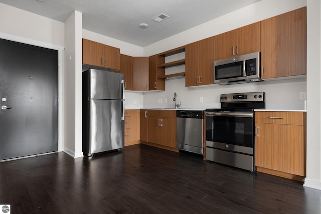 kitchen with dark wood-type flooring, stainless steel appliances, and sink