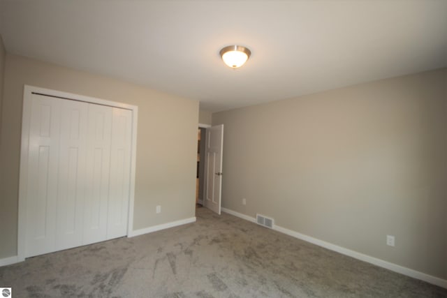 unfurnished bedroom featuring carpet floors and a closet