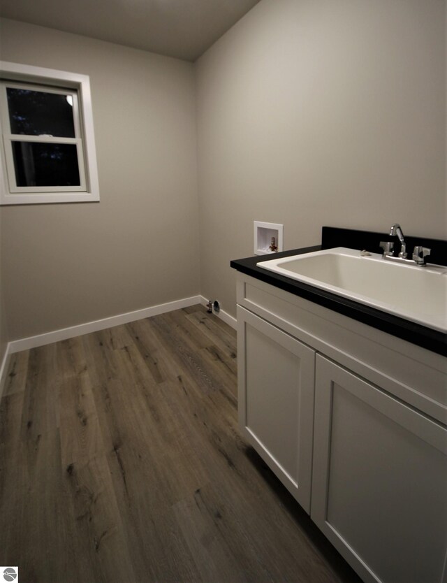 washroom featuring cabinets, sink, dark hardwood / wood-style flooring, and hookup for a washing machine