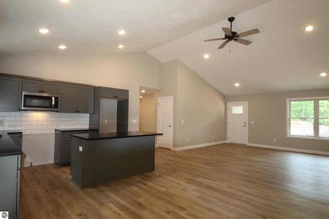 kitchen with tasteful backsplash, dark hardwood / wood-style floors, gray cabinets, and a center island