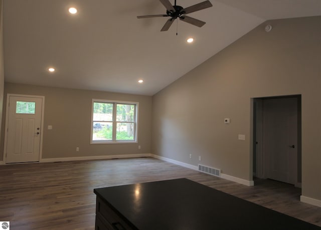 unfurnished living room with ceiling fan, dark hardwood / wood-style floors, and high vaulted ceiling