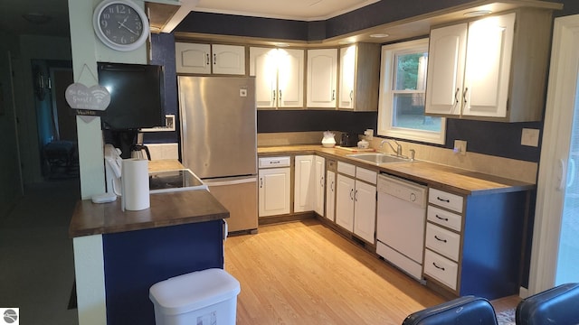 kitchen with white dishwasher, light hardwood / wood-style floors, stainless steel refrigerator, sink, and white cabinets