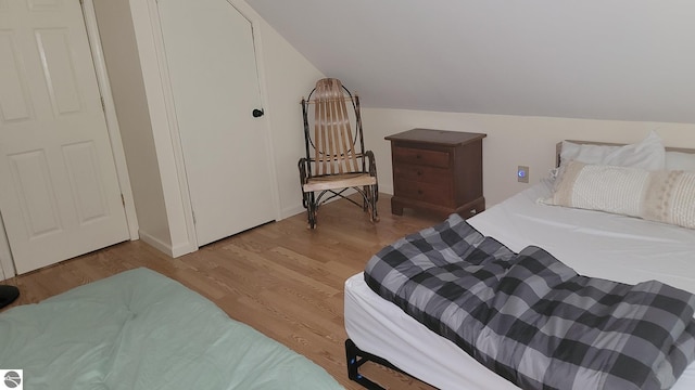 bedroom with lofted ceiling and hardwood / wood-style floors