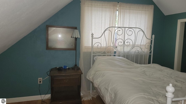 bedroom featuring lofted ceiling and wood-type flooring