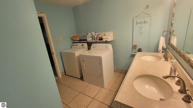 clothes washing area with light tile patterned floors, sink, and separate washer and dryer