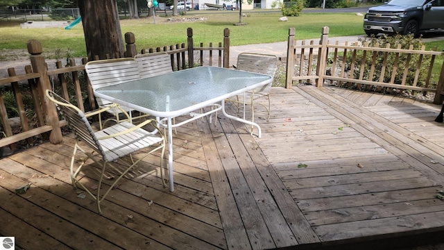 wooden deck featuring a lawn