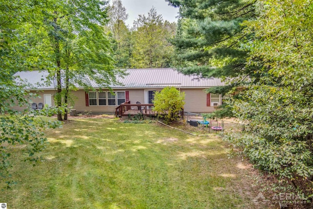 back of house featuring a lawn and a wooden deck