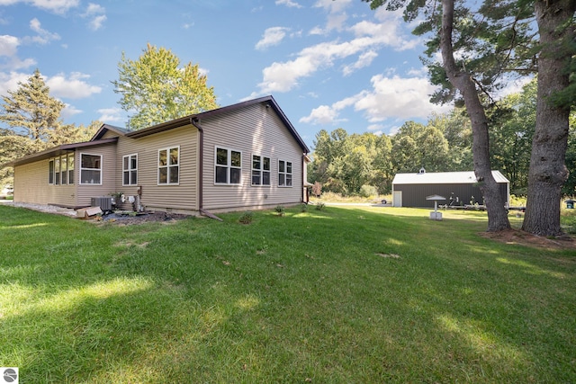 back of house featuring a lawn and cooling unit