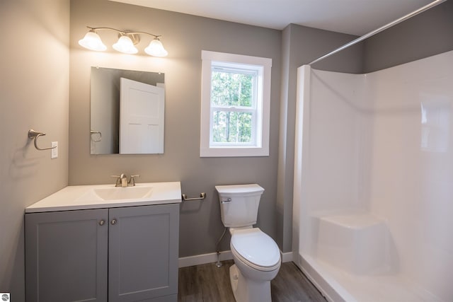 bathroom featuring vanity, toilet, wood-type flooring, and walk in shower