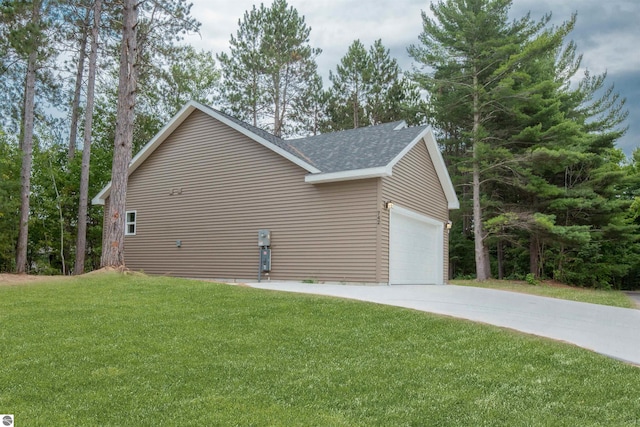 view of side of property featuring a garage and a lawn