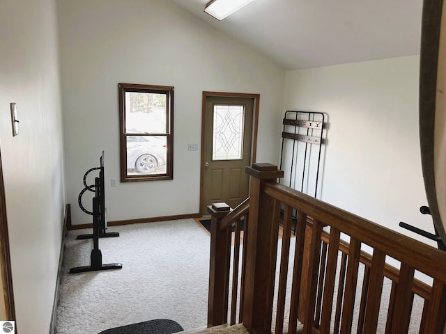 foyer featuring carpet floors and vaulted ceiling