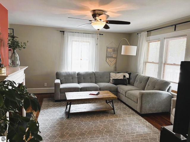 living room featuring dark wood-type flooring and ceiling fan