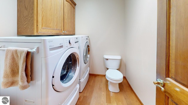 clothes washing area featuring separate washer and dryer and light hardwood / wood-style floors