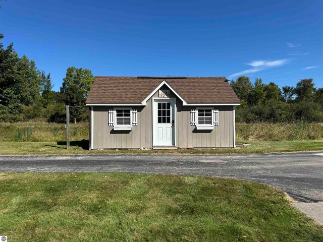 view of front facade with an outdoor structure and a front lawn