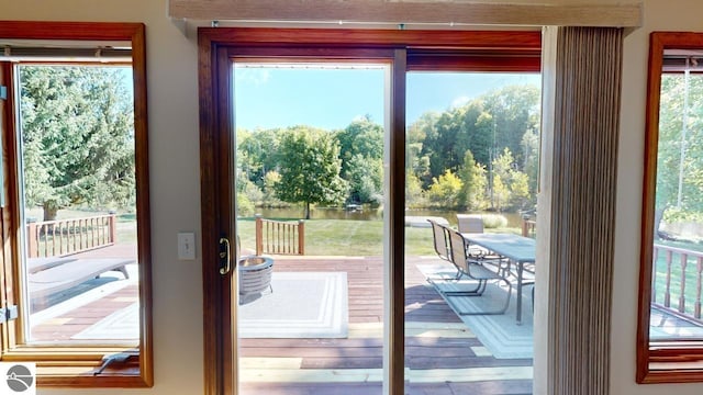 doorway to outside featuring hardwood / wood-style flooring and a water view