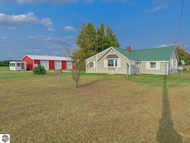 ranch-style home featuring a front lawn and an outbuilding