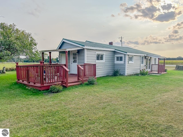 rear view of house with a yard and a deck