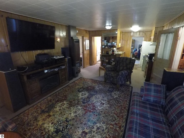 living room featuring wood walls and light colored carpet