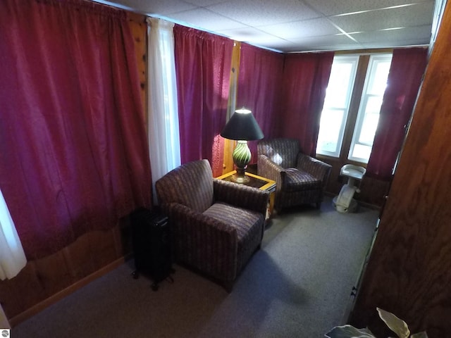 sitting room with a drop ceiling and carpet floors