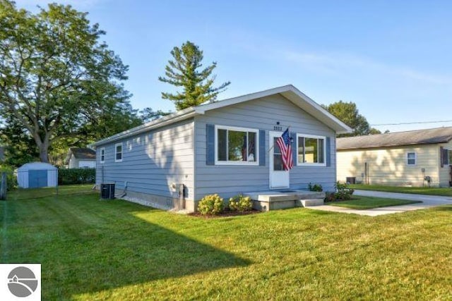 view of front of property featuring a front lawn and a shed