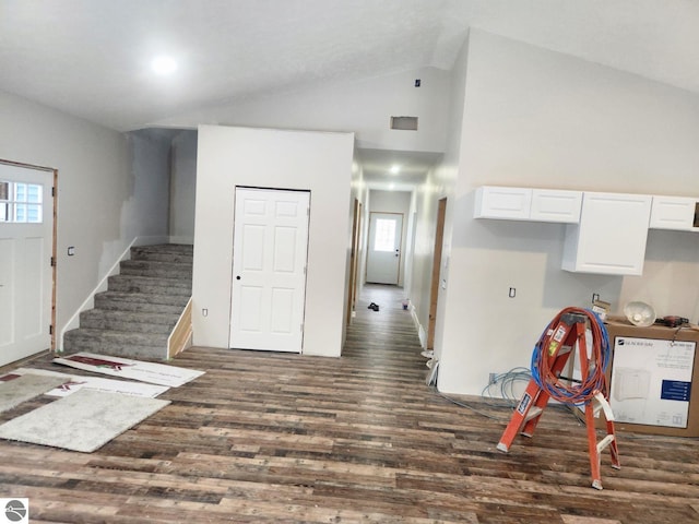 interior space with dark hardwood / wood-style flooring and high vaulted ceiling