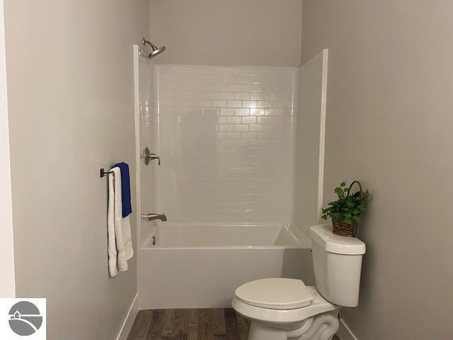 bathroom with toilet and washtub / shower combination