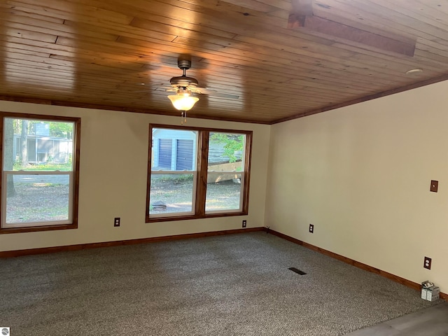 carpeted spare room with ceiling fan, plenty of natural light, ornamental molding, and wooden ceiling