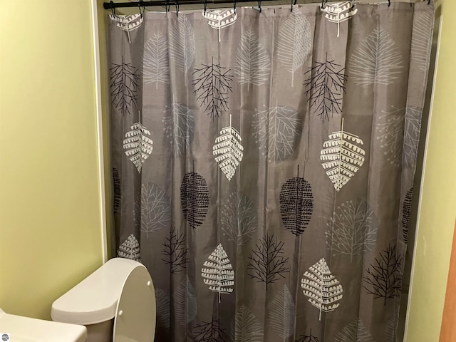 bathroom with curtained shower and toilet