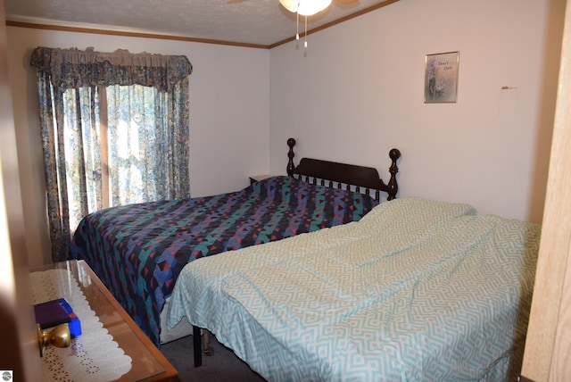 bedroom featuring crown molding, a textured ceiling, carpet floors, and ceiling fan