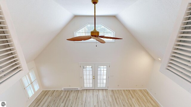 unfurnished sunroom featuring french doors, a baseboard radiator, a wealth of natural light, and ceiling fan