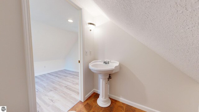 empty room featuring lofted ceiling with beams, wood walls, light wood-type flooring, ceiling fan, and a baseboard heating unit