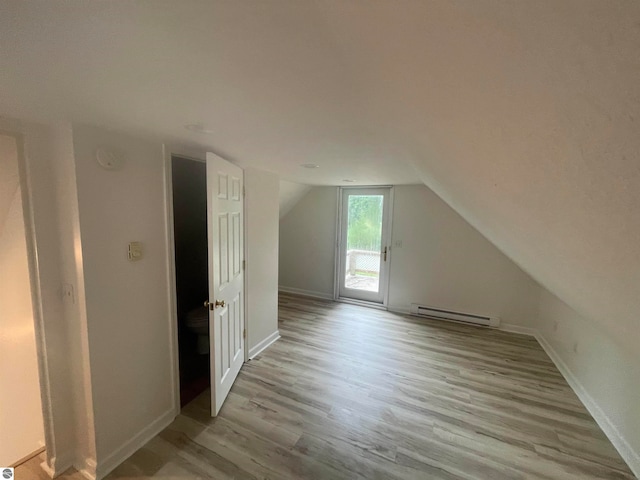 bonus room featuring light wood-type flooring, lofted ceiling, and a baseboard radiator