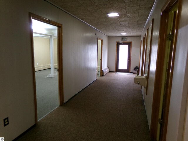 hall with baseboard heating and light carpet