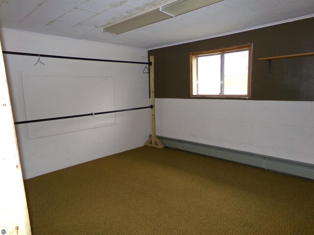 basement with carpet flooring, baseboard heating, and ornamental molding