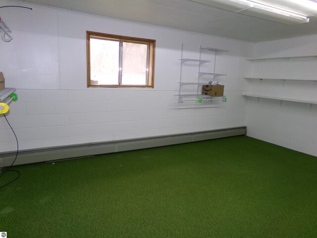 basement featuring a baseboard radiator and carpet