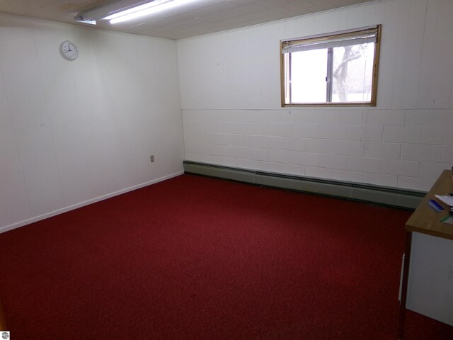 carpeted empty room with a baseboard heating unit