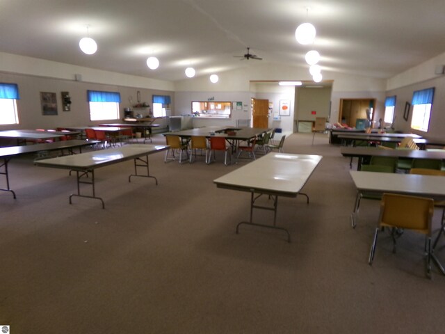 carpeted dining space featuring lofted ceiling and ceiling fan