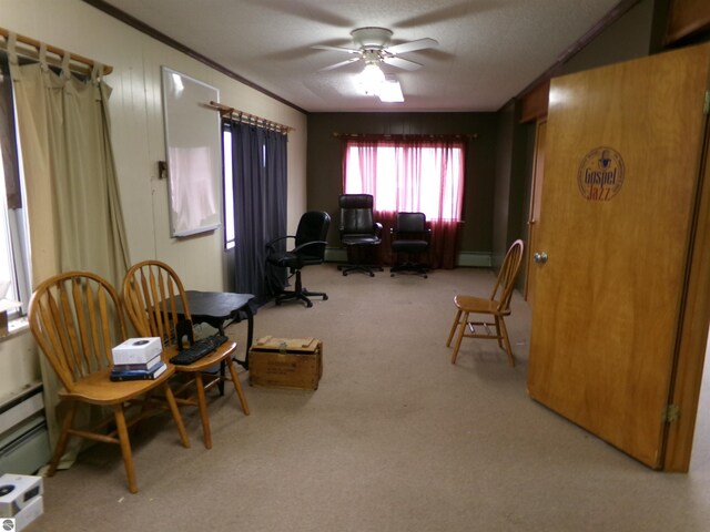 sitting room with ceiling fan, a baseboard radiator, light carpet, and a textured ceiling