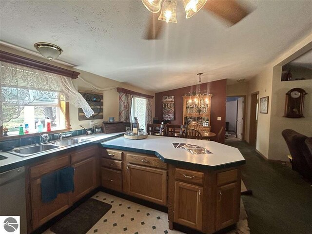 kitchen with dishwasher, a textured ceiling, decorative light fixtures, sink, and a chandelier