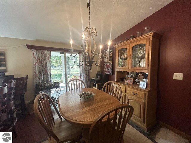 dining area with lofted ceiling, carpet flooring, and a chandelier