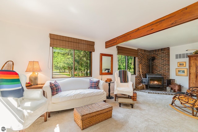 bedroom with carpet floors, beamed ceiling, and a wood stove