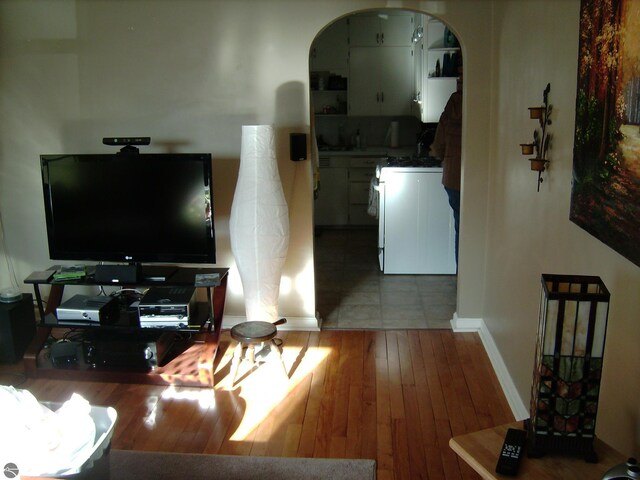 413 N Fancher St, Mount Pleasant, MI 48858 - living area with baseboards, arched walkways, and wood-type flooring