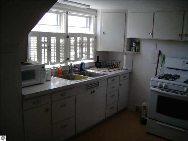413 N Fancher St, Mount Pleasant, MI 48858 - kitchen with white cabinetry, white appliances, light countertops, and a sink