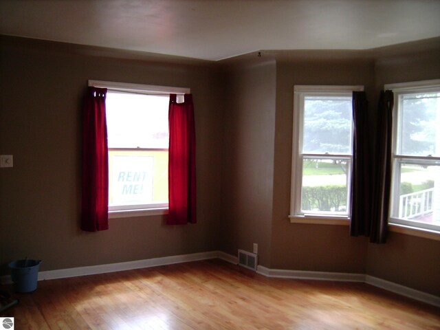 413 N Fancher St, Mount Pleasant, MI 48858 - unfurnished room featuring visible vents, baseboards, and light wood-style flooring