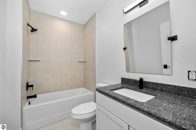 full bathroom with tiled shower / bath, vanity, and toilet