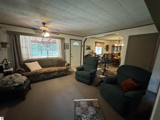 carpeted living room with ceiling fan with notable chandelier